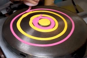 Dùng dụng cụ trải đều bột trên vỉ nướng bánh